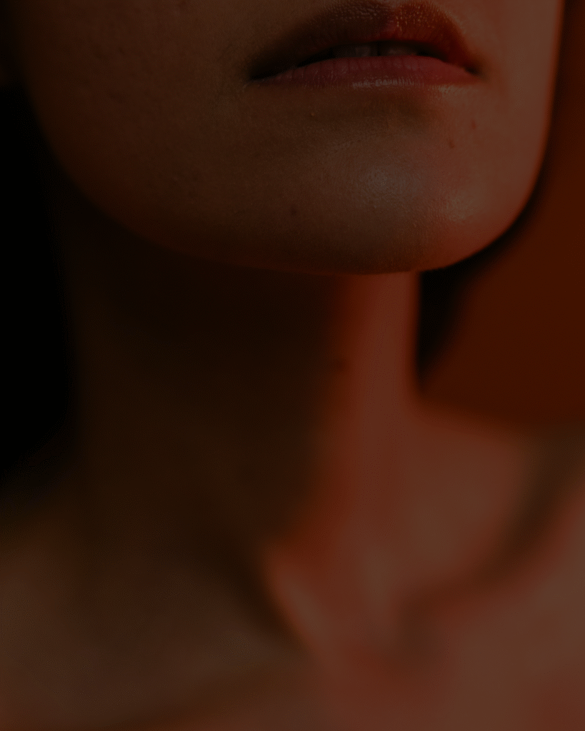 Gros plan sur le bas du visage et le cou d’une femme, mettant en évidence la peau, les lèvres et la mâchoire